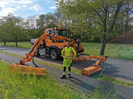Grasmahd und Bankettpflege durch Mulchen mit einem Unimog an Straßenrändern