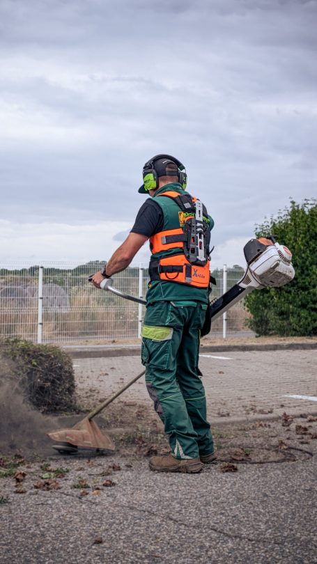 Mulchmahd und Wildkrautbeseitigung mit Freischneider und Wildkrautbürste in einem Betriebsgelände in Rossau